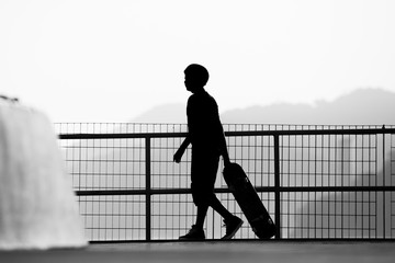 Silhouette of a skateboarder dragging his skateboard