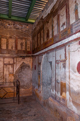 Fototapeta na wymiar Pompeii, the best preserved archaeological site in the world, with houses, squares and historical remains of the Roman Empire. Frescoes on the interior wall at home.