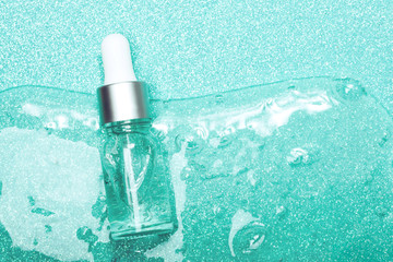 Face serum close-up on the trendy mint background. Collagen, hyaluronic acid for skin care....