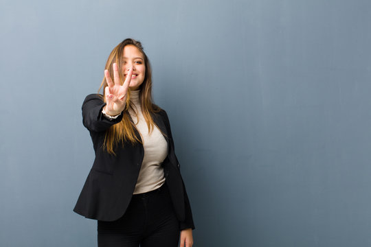 businesswoman smiling and looking friendly, showing number three or third with hand forward, counting down