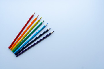 Set of seven sharp rainbow-colored pencils from top view on a white background. Concept of...