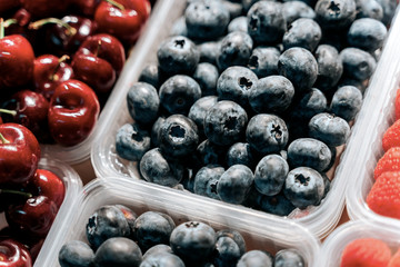 Fresh berries at display on the market stall. Blueberry, raspberry, blackberry.