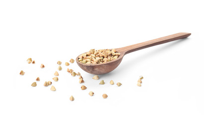 Uncooked green buckwheat grains in spoon isolated on white