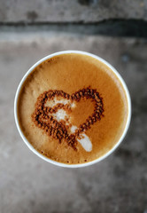 a cup of coffee (cappuccino) with milk foam and a heart shaped pattern of cinnamon, urban concept, mobile photo
