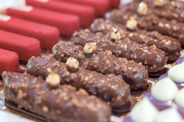 Assorted colorful eclair displayed in glass showcase box
