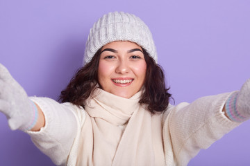Portrait of good looking young lady extending her hands, smiling sincerely, looking directly at...