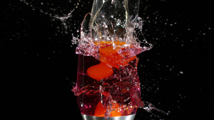 Glass lava lamp shattering among black background