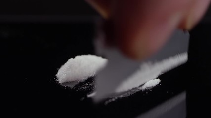 Close-up of cocaine getting cut into lines with a razor on a mirrored surface - Powered by Adobe