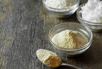 organic coconut flour in glass bowl along with a spoonful of coconut flour.