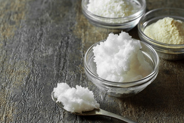organic virgin coconut oil in glass bowl along with a spoonful of coconut oil.