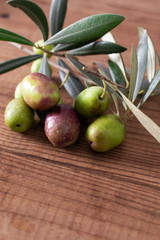 natural olives with olive branches and rustic wooden background