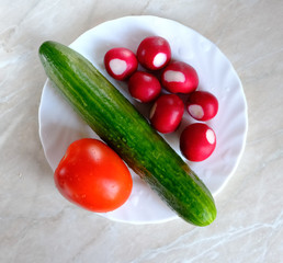 vegetables on a dish, tomato, cucumber and radish