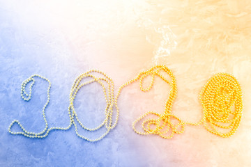 Christmas decoration. New year 2020 figures made of gold beads on cement background. Christmas concept with beads. Decorative design Christmas with New year 2020. Top view. Flat lay