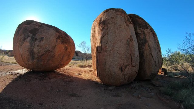 Australia, Northern Territory. Aboriginal land in Red Centre. Sunbeams sky at sunrise at Karlu Karlu - Devils Marbles Conservation Reserve.