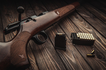 Classic bolt carbine .22lr with a wooden butt on a dark wooden surface. Weapons and cartridges for...