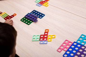 On a wooden table are multi-colored details from a children's educational game for learning colors and counting.