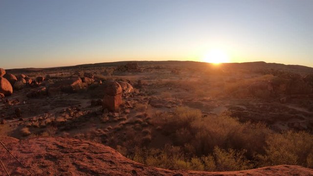 Sunbeams light and sunset colors sky over giant granite boulders at Karlu Karlu or Devils Marbles in Northern Territory, Australia. Nyanjiki Lookout atop view.