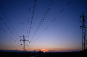 Fototapeta na wymiar High voltage electric tower and powerlines at sunset