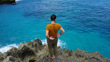 man looking at coral reef in rocky sea