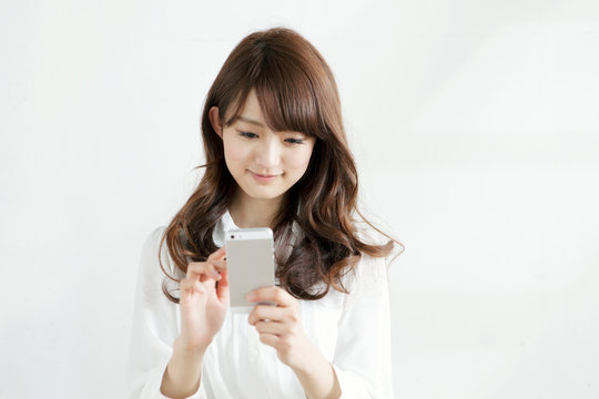 携帯電話を操作する女子大生