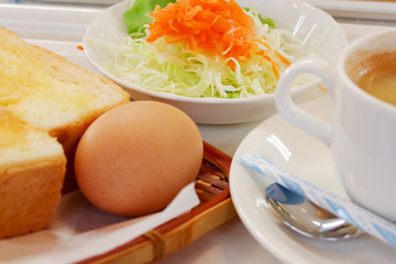 tokyo, japan, 11/17/2019 , japanese breakfast served in a japanese restaurant with boiled egg, toast, salad and latte.