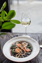 Black Conchiglie Pasta Shells with Seafood and Spinach. Modern Cafe Lunch.