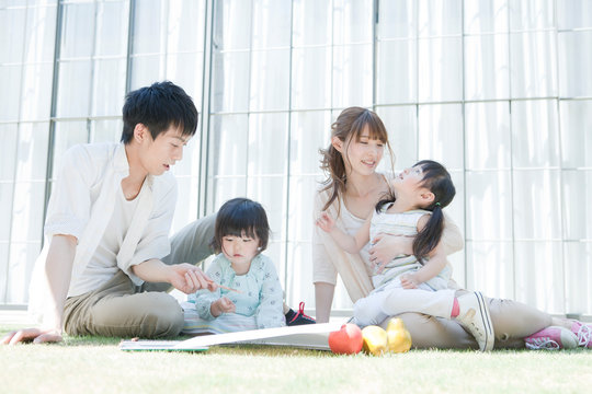 庭でくつろぐ両親と子供2人