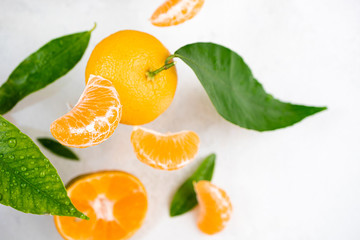 Tangerine, mandarines, clementine, citrus fruits with green leaves on white. Fresh tangerines citrus fruits background. Top view, copy space