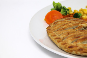 Pie and vegetable dinner on a plate