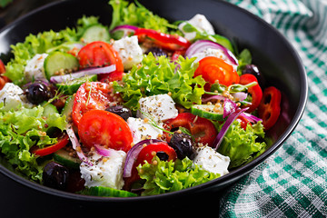 Healthy food. Greek salad with cucumber, tomato, sweet pepper, lettuce, red onion, feta cheese and olives.
