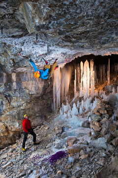 Lights illuminate unique ice stalagmites while climber  gets primitive on Caveman (M10), a hard mixed climb at Haffner Creek near Banff, Alberta.