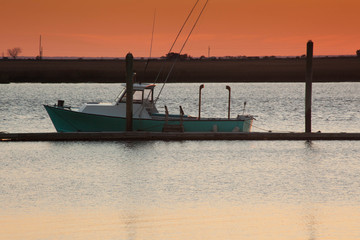 Fishing boats at a dock with sunrise