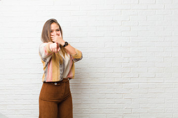 young pretty woman laughing at you, pointing to camera and making fun of or mocking you