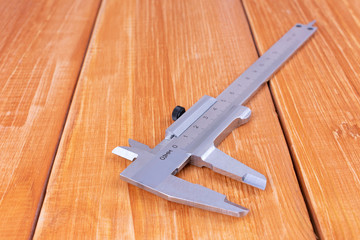 Caliper on a wooden background.