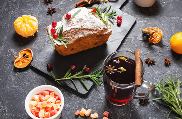 Hot mulled wine for winter and Christmas cake with delicious on stone background
