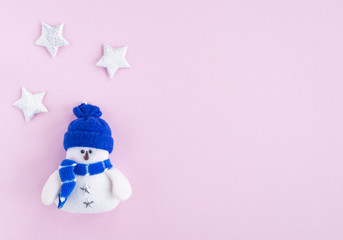 snowman and stars on pink background with place for copy space. Flat lay, top view.