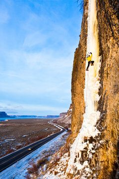 A man climbs H2O2 (WI5) at sunset near Banks Lake in Central Washington. This particicular route is so close to the highway that a resourceful partner can actually belay straight out of the car on the shoulder.