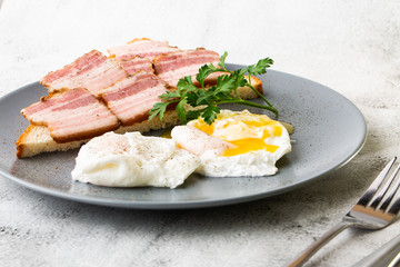 Poached eggs with bacon on sourdough toast. isolated on white marble background. Homemade food. Tasty breakfast. Selective focus. Hotizontal photo.