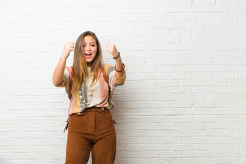 young pretty woman celebrating an unbelievable success like a winner, looking excited and happy...