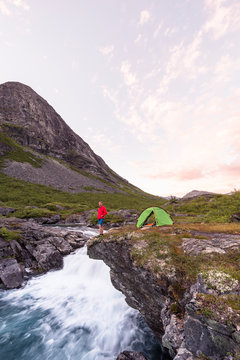 Eidsdalselva, M&macr;re og Romsdal, Norway: A male hiker at his camp on a cliff by the river.