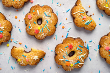 Delicious cookies on white background dusted with multicolored sprinkling.