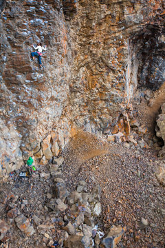 A woman climbing the pumpy 90-foot Pit Lizard (5.11a) in the PIt at Deep Creek, a climbing area near Spokane, Washington.