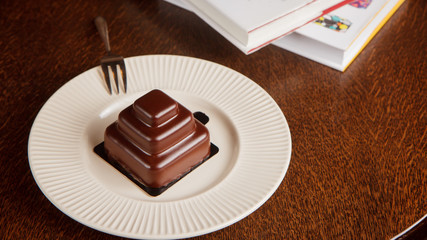 Beautiful chocolate gluten free cake with books on table.