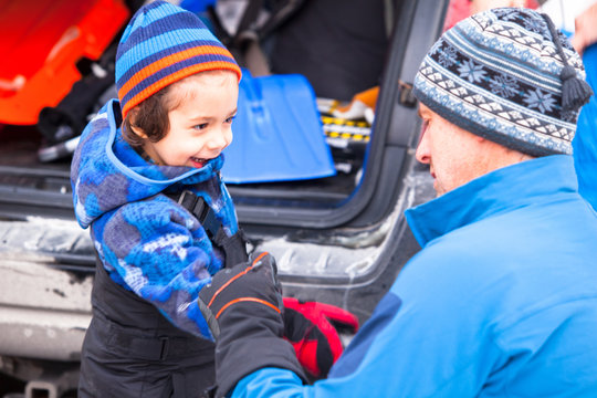 A man gets his 3.5-year-old son ready for some fun in the snow at the Green Hills Preserve.