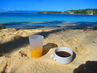 Café et jus de fruit pour un petit déjeuner à la plage face à la mer