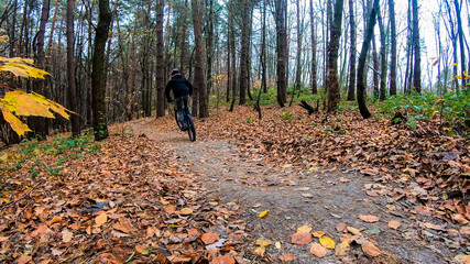 Amateur rider on the bicycle in the autumn park