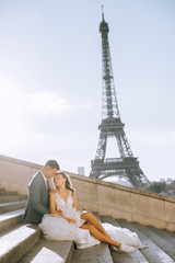 Happy romantic married couple hugging near the Eiffel tower in Paris