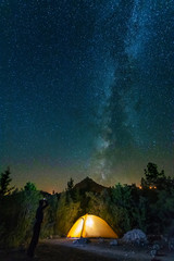 Fototapeta na wymiar starry night with the Milky Way on the Turkish Mediterranean coast amidst the rocky mountains with tourists in a yellow tent