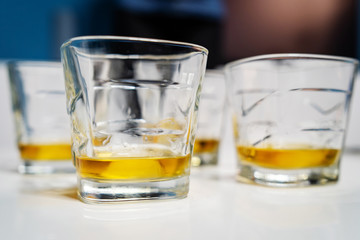 Close up on three glasses whiskey or brandy or cognac alcohol drink on the white table at home