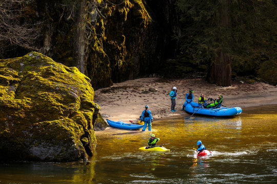 A a group of rafters and kayakers hanging out in a lush  idyllic bay on the Lochsa River in Idaho